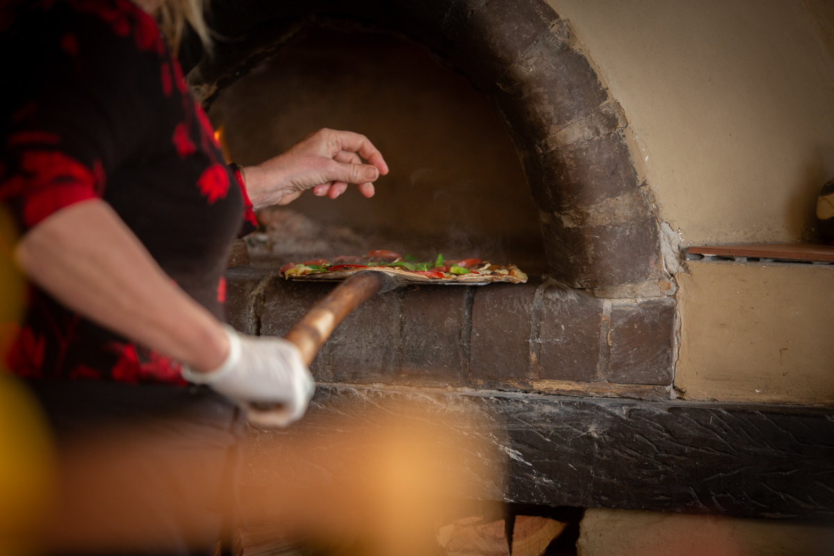Wood-fired pizza being taken from the oven at Beach House