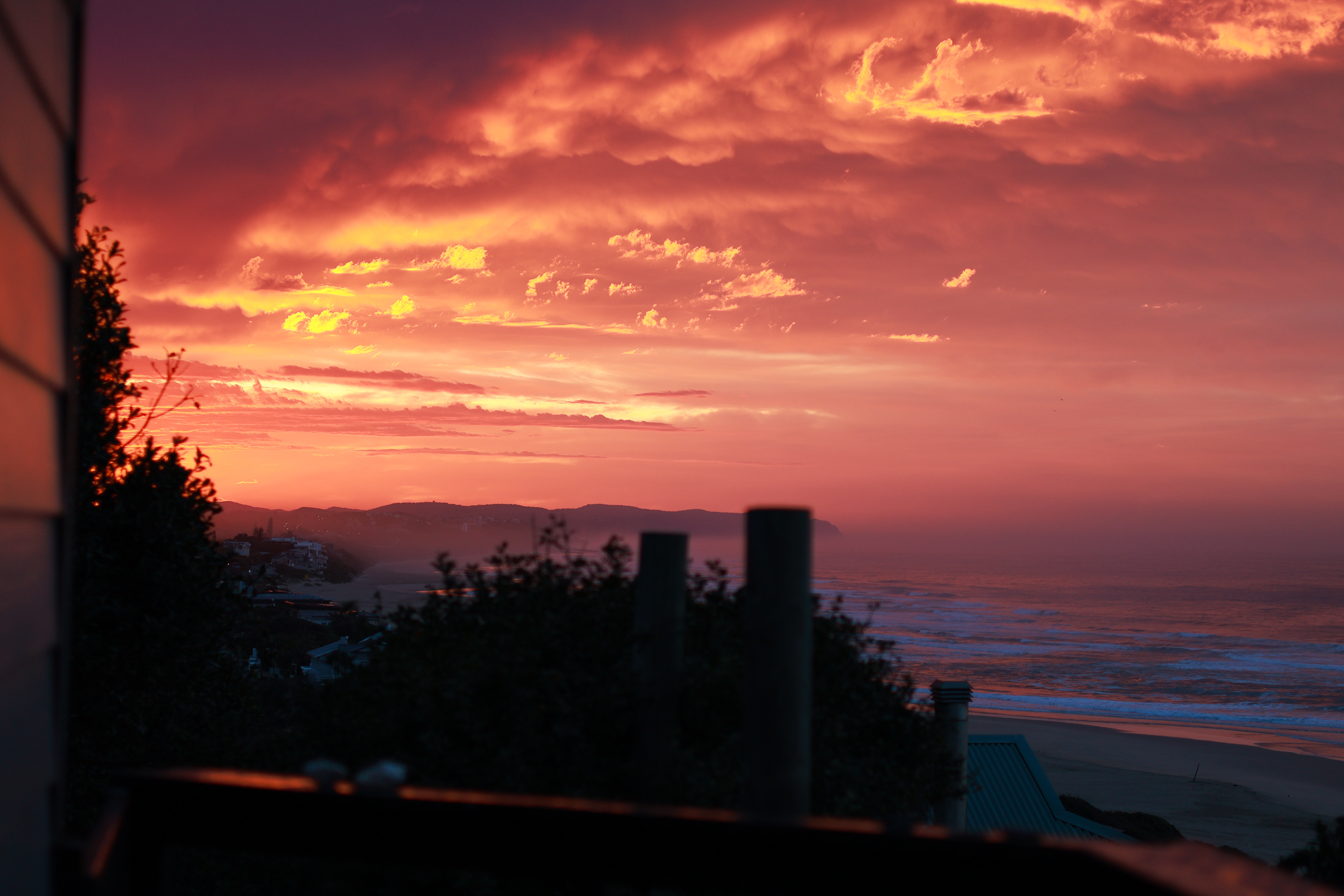 Dramatic orange sunset from Beach House balcony overlooking the Indian Ocean