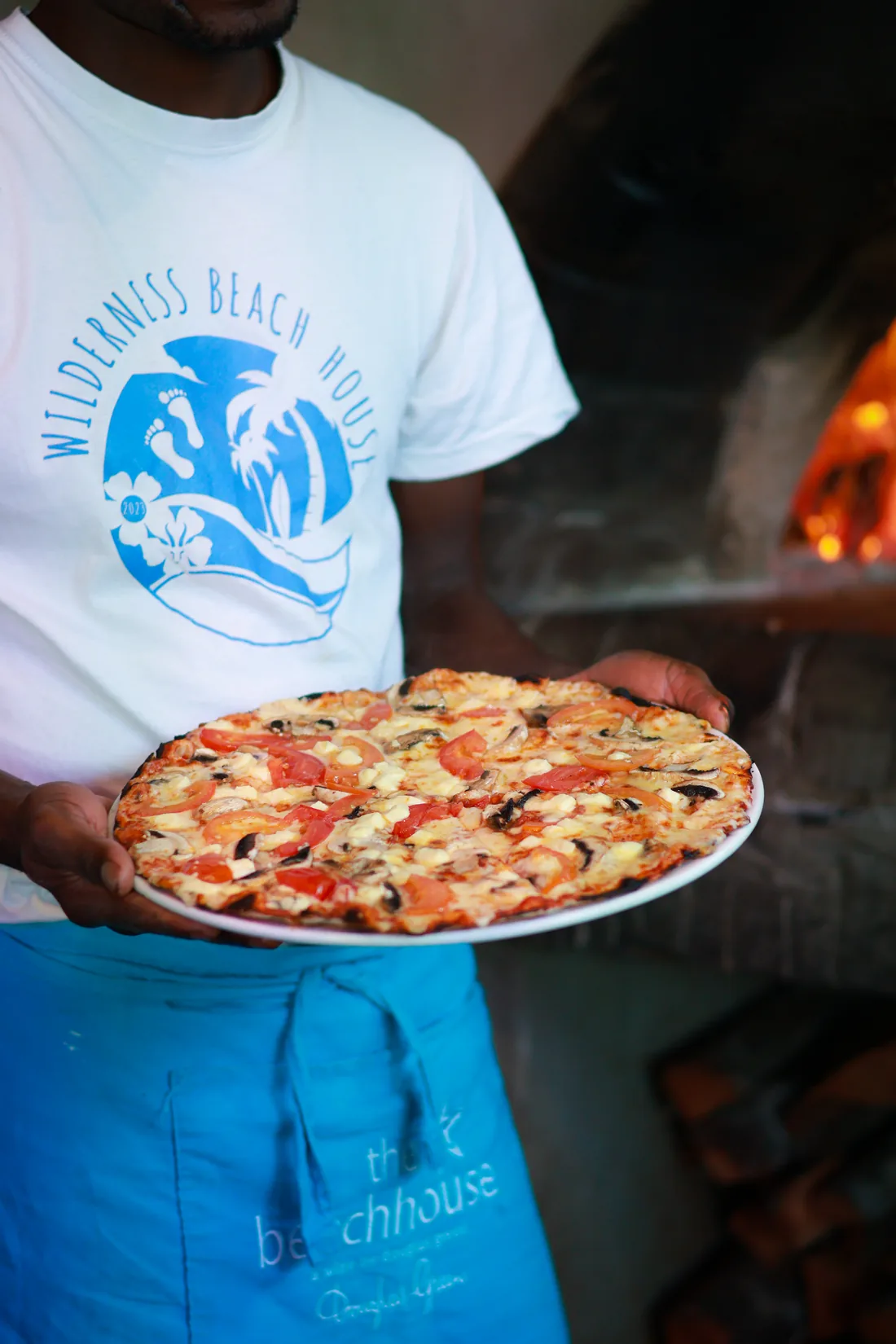 Beach House staff preparing a wood-fired pizza in Wilderness on the Garden Route